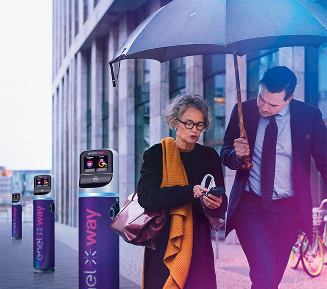 Un uomo e una donna camminano su un marciapiede accanto ad una JuicePole