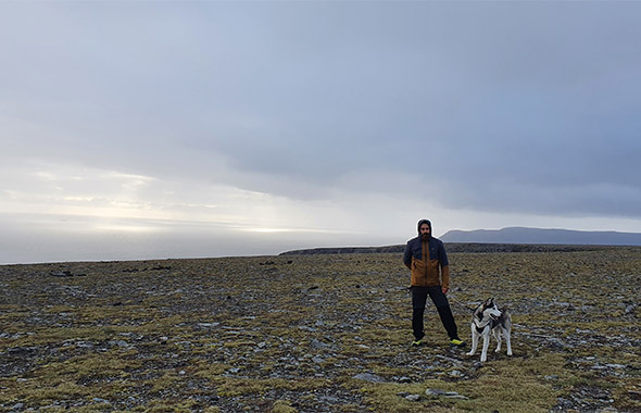 Luca con il suo cane husky a Capo Nord, su un altopiano a ridosso del mare